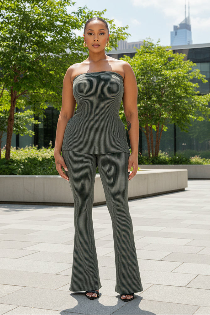A woman standing in a room with green ribbed tube pants set, including a tube-style top and high-waisted pants.