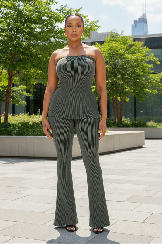 A woman standing in a room with green ribbed tube pants set, including a tube-style top and high-waisted pants.