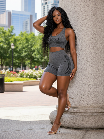 Woman in gray athletic wear posing outdoors with cityscape in the background
