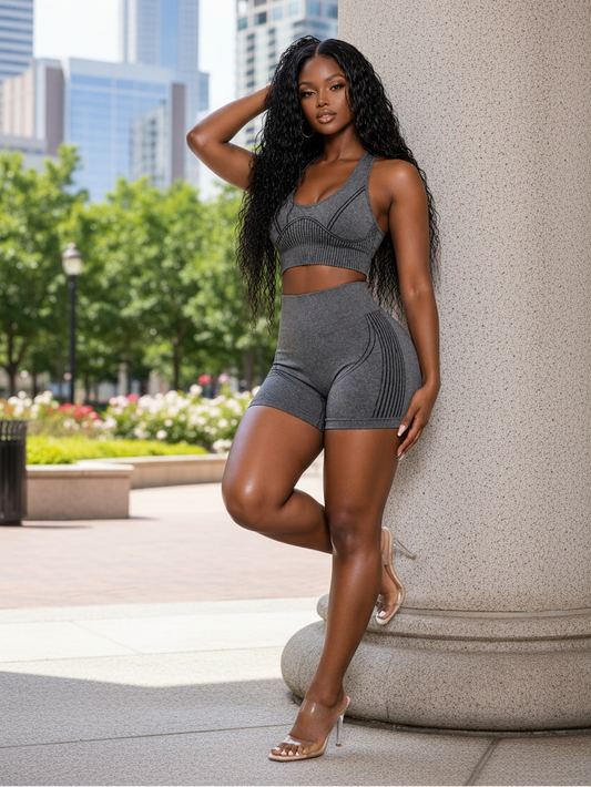 Woman in gray athletic wear posing outdoors with cityscape in the background