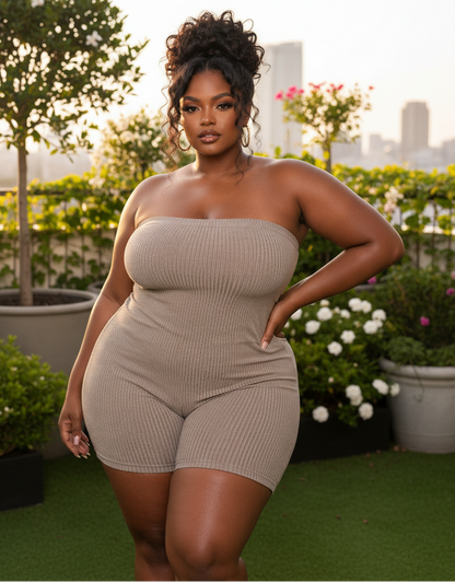 Woman in a beige strapless outfit standing on a rooftop with greenery and cityscape in the background