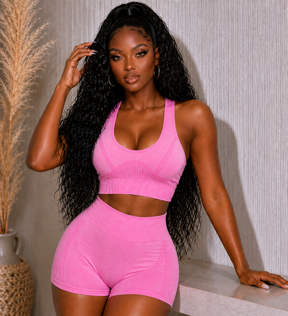 Woman wearing a pink sports bra and shorts set against a neutral background