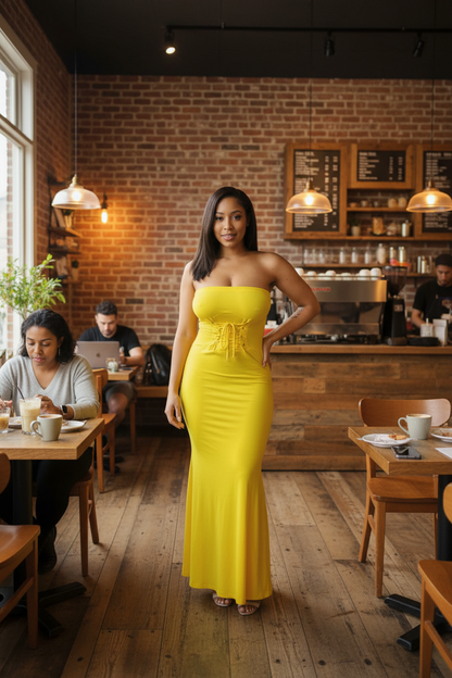Woman in a yellow dress standing in a cozy café with brick walls and wooden floors.